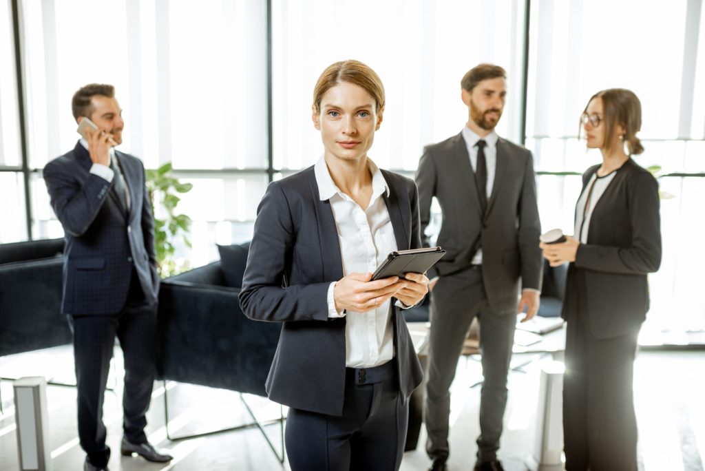 Portrait of a business woman with team indoors